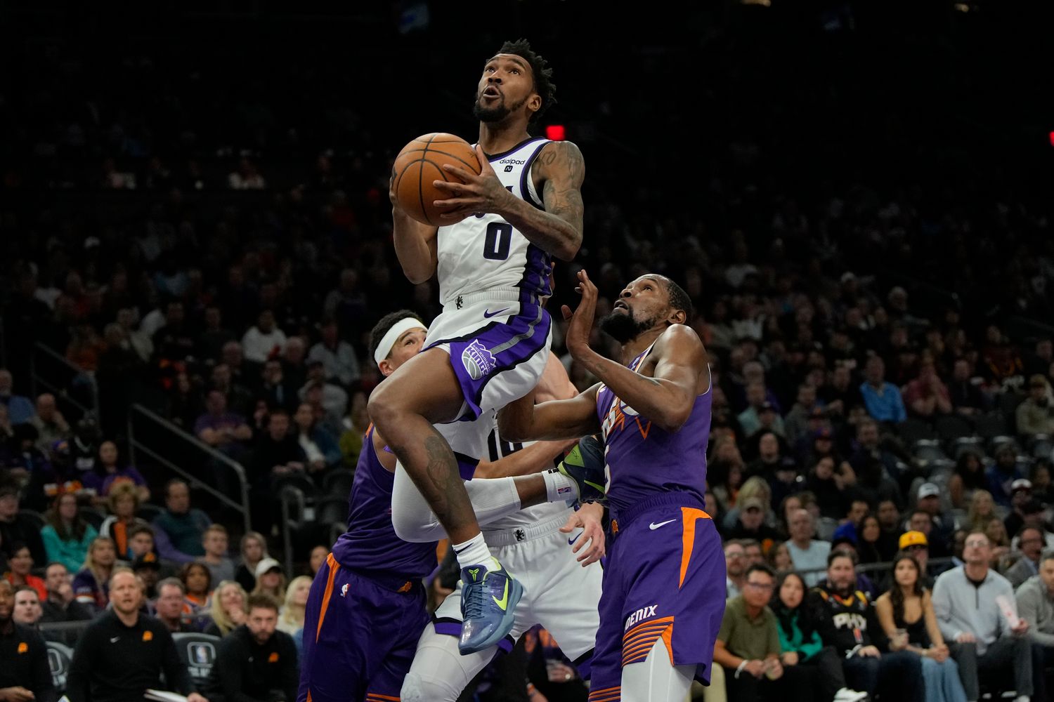 Sacramento Kings guard Malik Monk (0) drives on Phoenix Suns forward Kevin Durant (35) in the second half at Footprint Center.